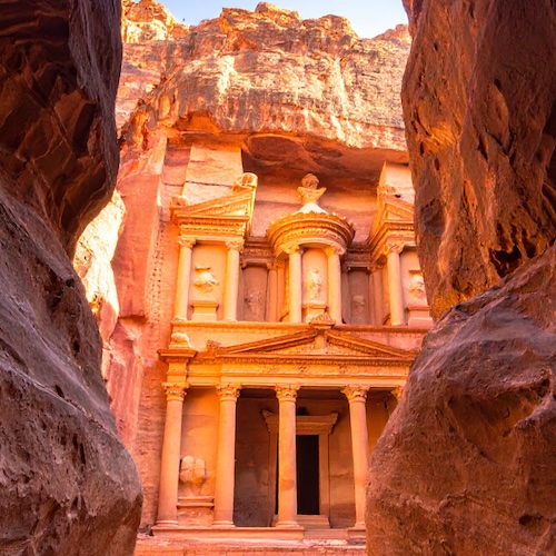 ancient structure viewed through an opening between two mountains