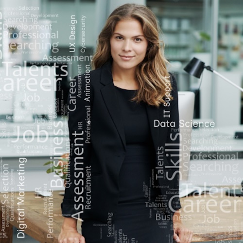 young business woman standing in front of a desk with tech and business words overlayed over the image