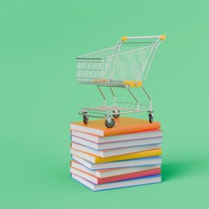 "Buy, Now, Pick Later" - Shopping cart standing on a stack of colorful books over green background